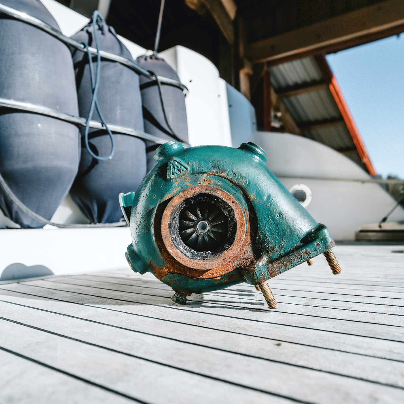 Turboaggregat på ett båtdäck före retusch: grön lack med rost och smuts på detaljerna