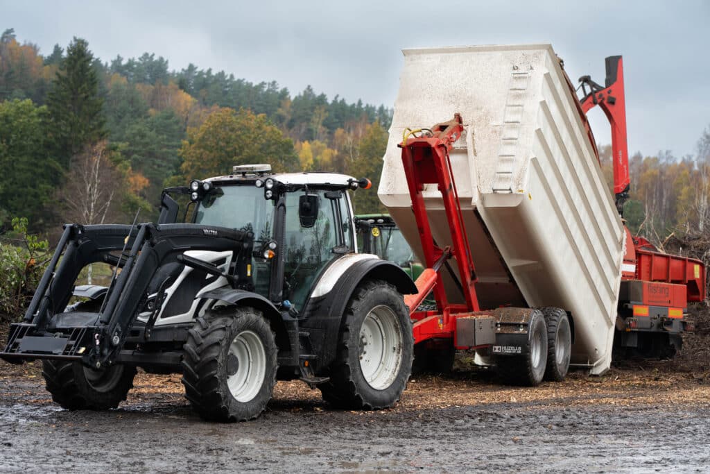 Valtra-traktor vid flisning i Hjälteby på Tjörn, höstljus