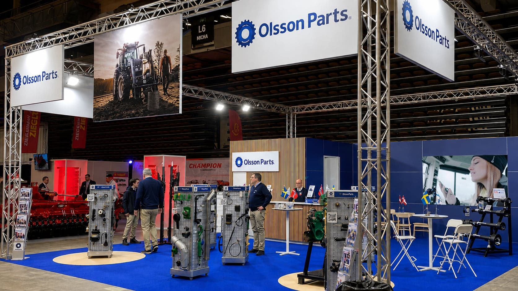 Olsson Parts monter på lantbruksmässan Agromek i Herning: en takbanderoll med foto av en traktor, och en skärm som spelar film från en traktorhytt