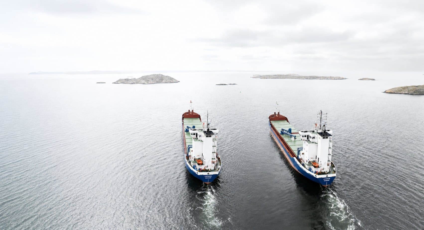 Två lastfartyg från Rederi AB Uman som möts mellan skär i skärgården