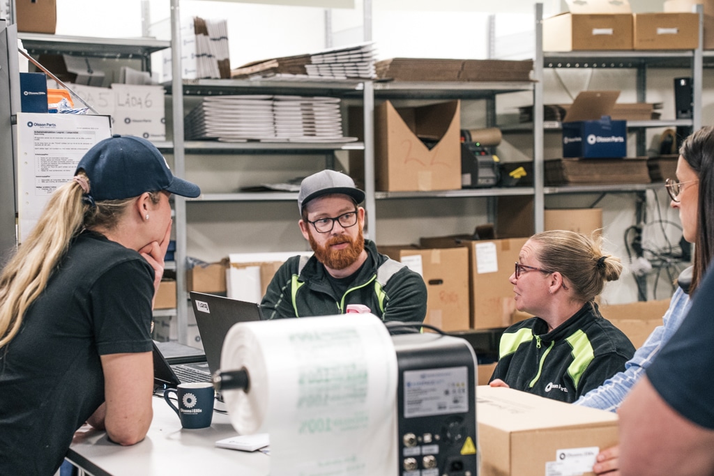 Personal hos Olsson Parts i samtal vid packbordet i lagret
