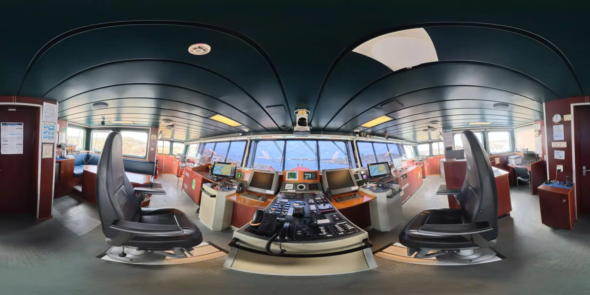 Bryggan på M/V Lister sedd som ett utplattat panorama: manöverpanel, sjökortsskärmar och fönsterrad ut mot skärgården.